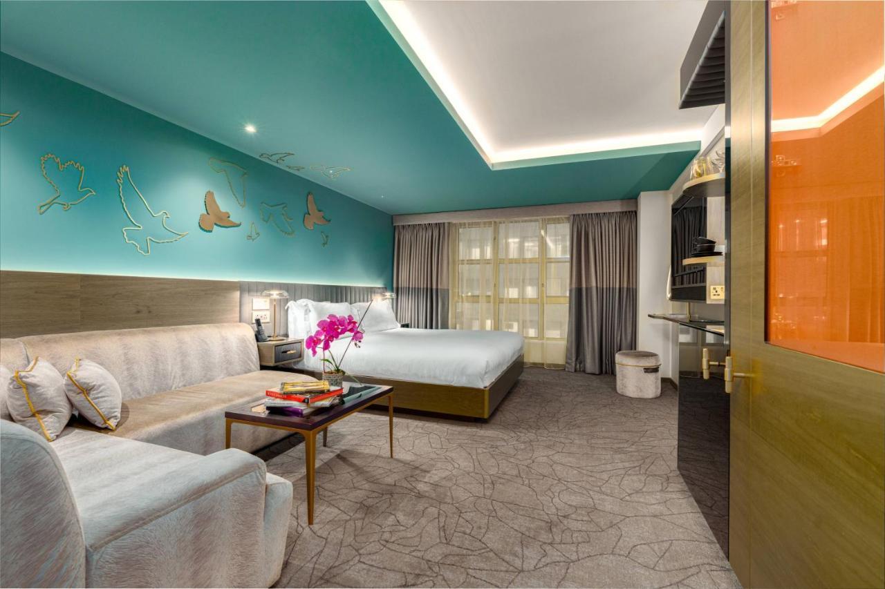 Middle Eight - Covent Garden - Preferred Hotels And Resorts Londra Esterno foto The photo shows a modern hotel room featuring a blend of comfort and style. The room has a light-colored floor with a textured design, and the walls are adorned with a vibrant turquoise accent wall that features decorative butterfly motifs. 

There i