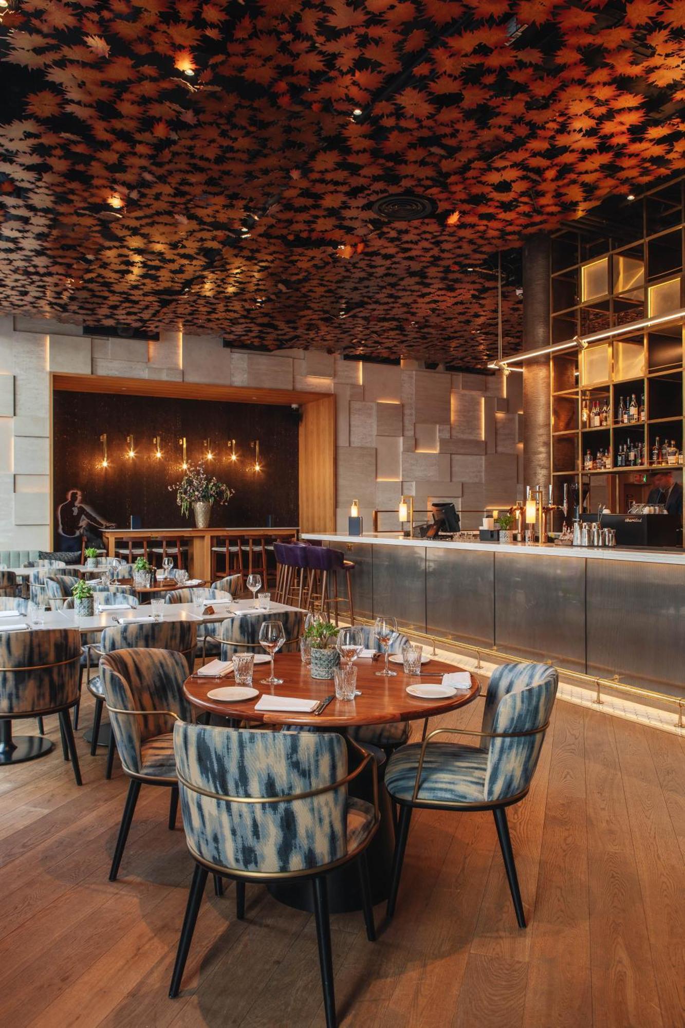 Middle Eight - Covent Garden - Preferred Hotels And Resorts Londra Esterno foto The photo shows a stylish restaurant interior. There are round tables set with plates and glasses, surrounded by comfortable chairs. The bar area is sleek and modern, with a counter displaying various bottles. The lighting appears warm and inviting, 