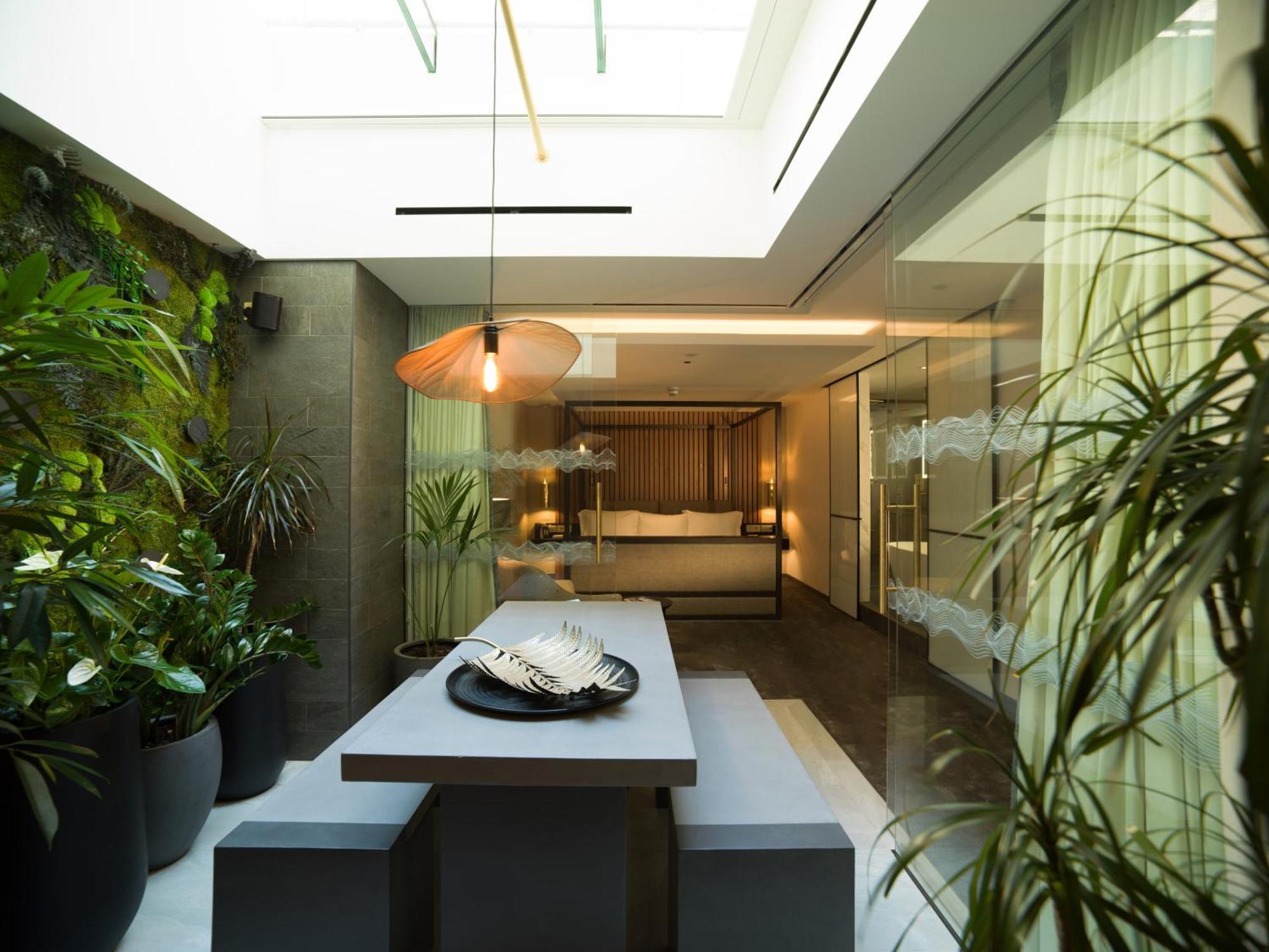Middle Eight - Covent Garden - Preferred Hotels And Resorts Londra Esterno foto The photo depicts a modern, airy interior space that features a dining area. The dining table is rectangular and made of a light-colored material, paired with simple benches on either side. Above the table, there is a stylish pendant light, providing